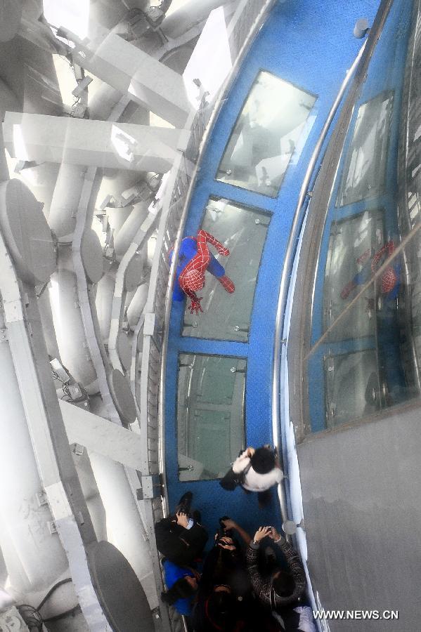 A working staff dressed up like a spider-man performs in the opening ceremony of the Canton Tower Spider Walk in Guangzhou, capital of south China's Guangdong Province, April 2, 2013. The 1,000-meter-long Spider Walk locates at the 168-meter to 334.4-meter height of Canton Tower, with a transparent floor made up of 90 pieces of glasses. Visitors would get a general view of the scenery of Guangzhou City from the Spider Walk. (Xinhua/Shen Dunwen) 