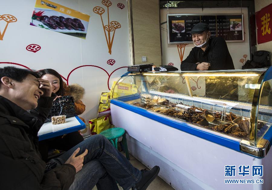 Qi Fayi chats with customers in his snack shop. (Xinhua Photo/ Wang Fei)