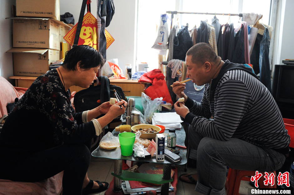 Qi Fayi has a light breakfast with his mother. His father was hospitalized for a sudden heart attack. (Chinanews.com/ Liu Xin)