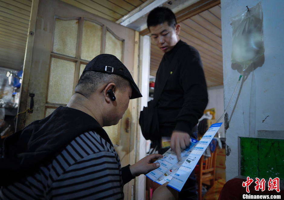 Qi has his peritoneal dialysis in a cook shop owned by his relative. He is busying discussing with his friend on partnership of a snack shop. Faced with high medical expenses, Qi wishes to run a snack shop to make end meet. (Chinanews.com/ Liu Xin)
