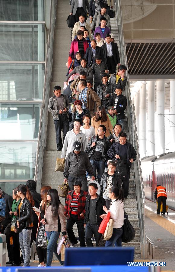 Passengers walk down from a crossover to take trains at the Yinchuan Railway Station in Yinchuan, capital of northwest China's Ningxia Hui Autonomous Region, April 2, 2013. The railway station received a travel rush on April 2 as passengers rushed to return home to sweep the tombs of their deceased relatives during the Qingming Festival holidays, which falls on April 4-6 this year. The Qingming Festival is a traditional Chinese holiday for mourning the dead. (Xinhua/Peng Zhaozhi)