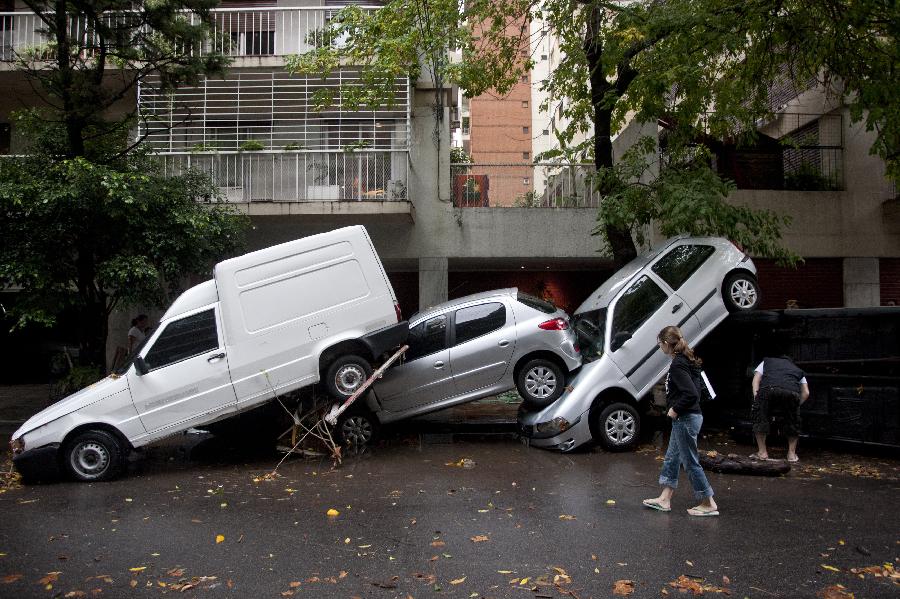 Residents watch vehicles damaged after a storm hit the city of Buenos Aires, capital of Argentina, on April 2, 2013. (Xinhua/Martin Zabala)  