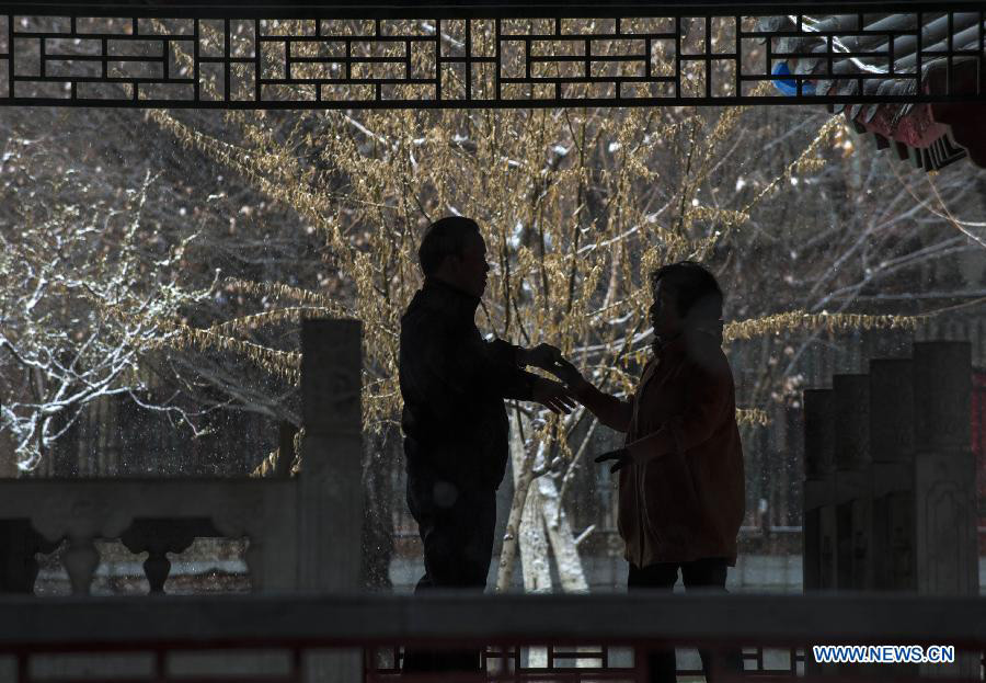 Citizens dance for exercises in sleet in Urumqi, capital of northwest China's Xinjiang Uygur Autonomous Region, April 3, 2013. A sleet hit the capital city of Xinjiang on Wednesday in the wake of sharp temperature drop. (Xinhua/Wang Fei)