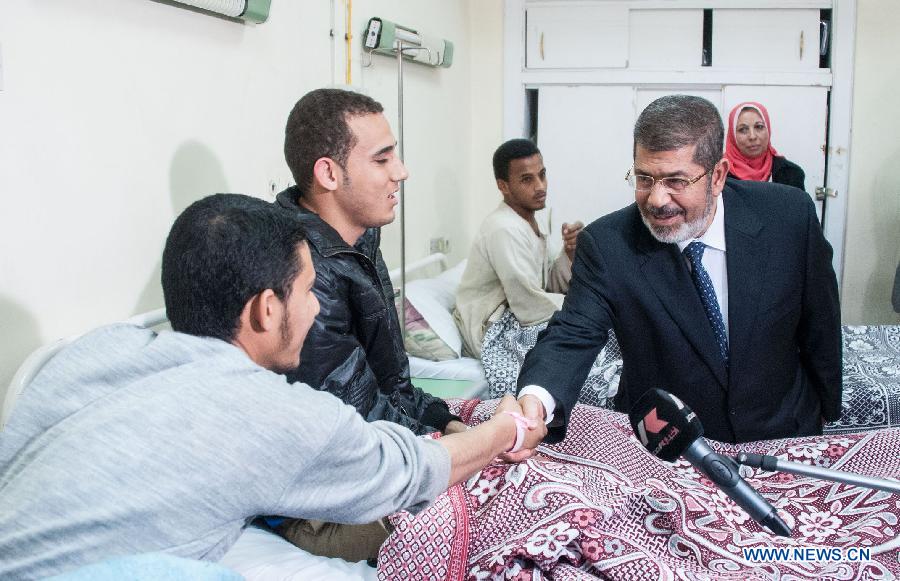 Egyptian President Mohamed Morsi (front R) visits al-Azhar University students who suffered food poisoning at a hospital in Cairo, Egypt, Apr. 2, 2013. As many as 561 Egyptian students of al-Azhar University have been infected with food poisoning on Apr, 1, with no deaths reported, spokesman for the Ministry of Health Yahia Moussa told Xinhua on Tuesday. (Xinhua/Qin Haishi) 