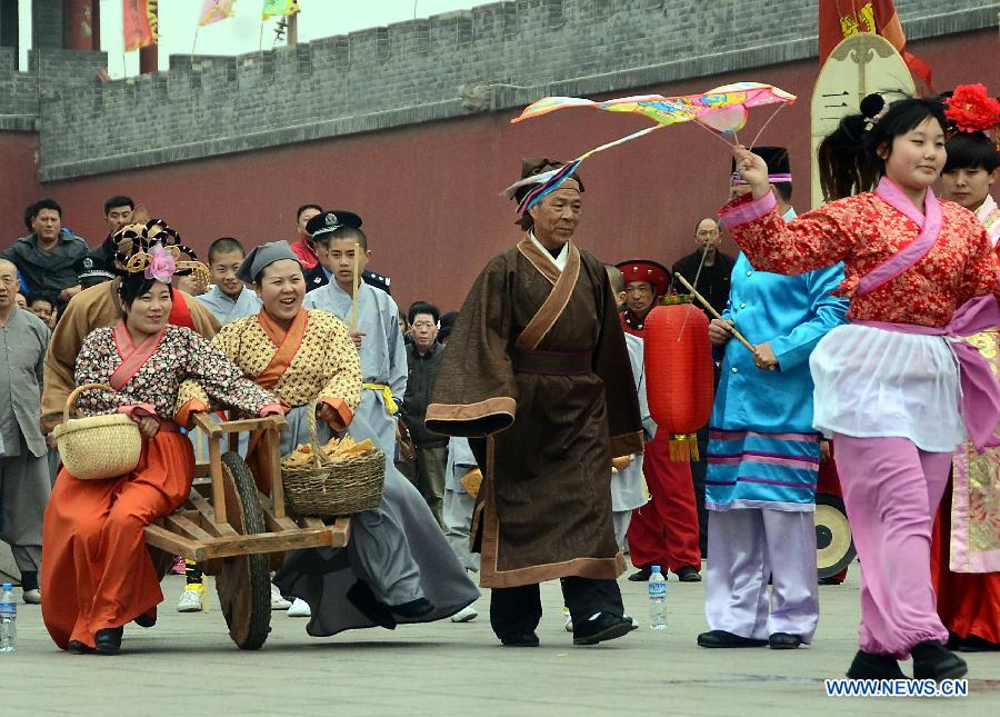 Performers dressed in costumes of Northern Song Dynasty (960-1127) walk along the road in a spring parade for the upcoming Tomb-sweeping Day in Kaifeng, central China's Henan Province, April 3, 2013. Thousands of performers and citizens participated in the parade. (Xinhua/Wang Song)