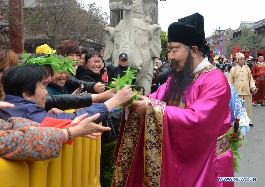 A performer dressed in costumes send out gifts to audience in a spring parade for the upcoming Tomb-sweeping Day in Kaifeng, central China's Henan Province, April 3, 2013. Thousands of performers and citizens participated in the parade. (Xinhua/Wang Song) 