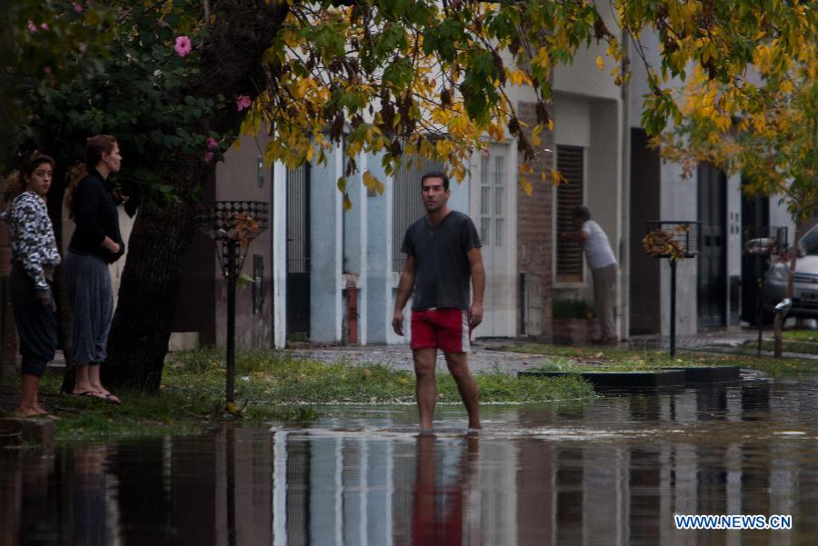 A man walks in flood in La Plata, 63 km south of Buenos Aires, Argentina, on April 3, 2013. At least 46 people have died due to heavy storms in La Plata, and another 3,000 have been evacuated, according to local media. (Xinhua/Martin Zabala) 