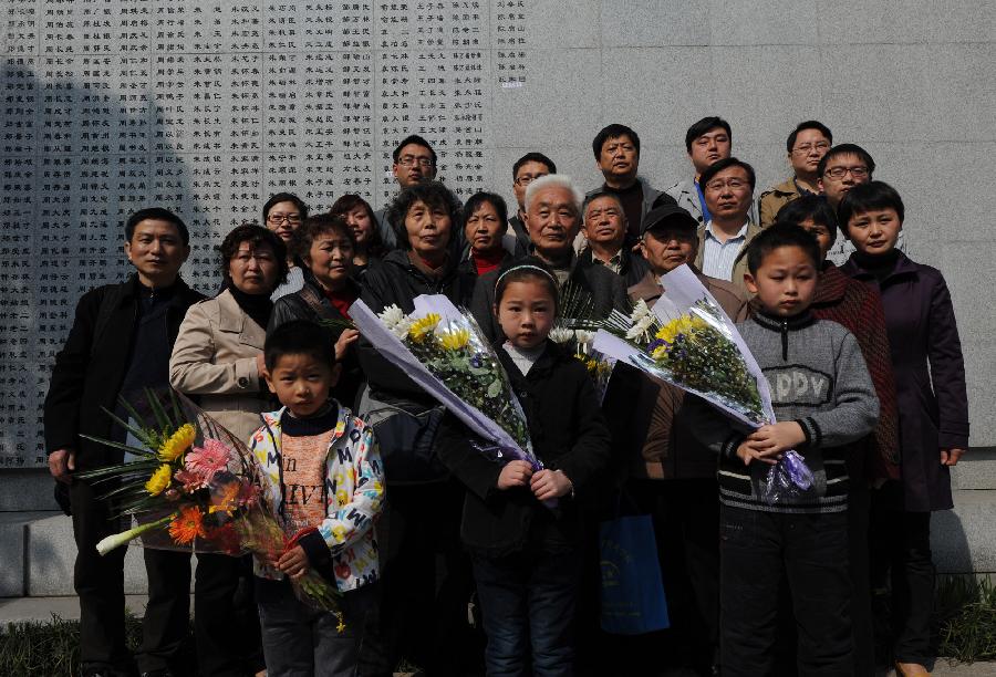 Duan Dingdong (4th R, 2nd line) poses for photo with his family in front of a wall with victims' names for the Nanjing Massacre in 1937 in the Memorial Hall of the Victims in Nanjing Massacre by Japanese Invaders, in Nanjing, capital of east China's Jiangsu Province, April 4, 2013. Ruan's grandfather was the victim of the massacre. Lots of citizens came here to mourn Nanjing Massacre victims on Thursday. (Xinhua/Han Yuqing) 