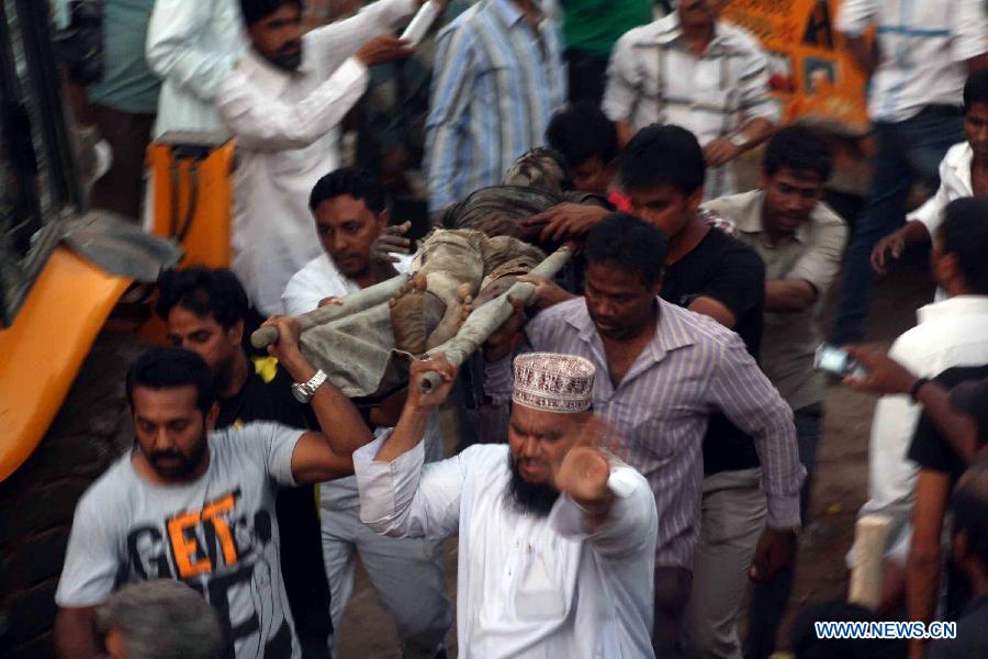 Rescuers take out a trapped victim after a building collapsed in Thane, Mumbai, India, April 4, 2013. At least 9 people died and over 40 people were injured when an under-construction residential building collapsed on Thursday evening, local media reported. (Xinhua/Stringer) 