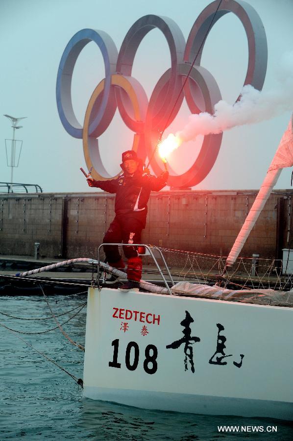 China's Guo Chuan celebrates after returning home in Qingdao, east China's Shandong Province, April 5, 2013. Guo sailed back home on Friday morning to become the first Chinese to successfully circumnavigate the globe singlehanded. Aboard his Class40 yacht, 48-year-old Guo travelled about 21,600 nautical miles in 138 days before he returned to his hometown of Qingdao, where he set off on November 18 last year. (Xinhua/Li Ziheng) 