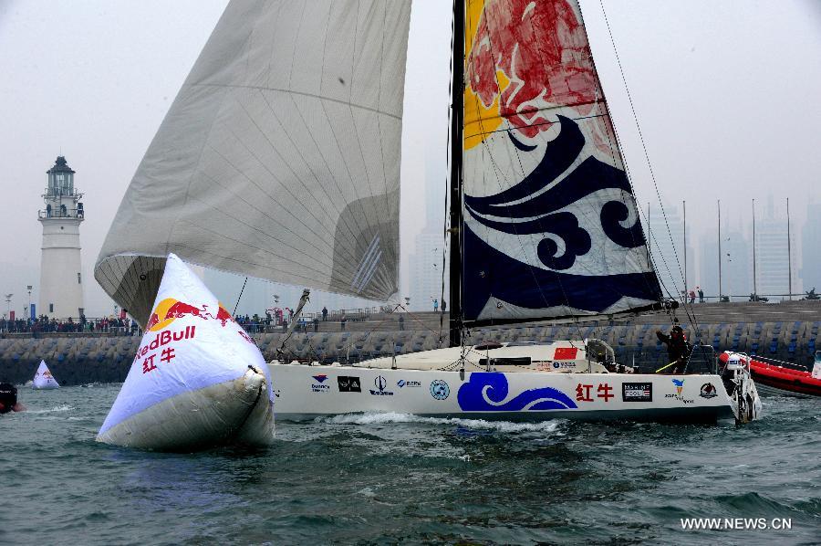 China's Guo Chuan passes a finish buoy on his boat in Qingdao, east China's Shandong Province, April 5, 2013. Guo sailed back home on Friday morning to become the first Chinese to successfully circumnavigate the globe singlehanded. Aboard his Class40 yacht, 48-year-old Guo travelled about 21,600 nautical miles in 138 days before he returned to his hometown of Qingdao, where he set off on November 18 last year. (Xinhua/Li Ziheng)