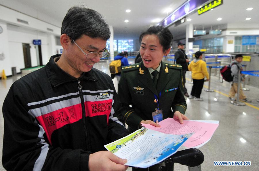 An officer from the China Immigration Inspection delivers a proposal for eco-friendly tomb-sweeping to a man from Taiwan in Fuzhou, capital of southeast China's Fujian Province, April 4, 2013. A green channel is set up during the Qingming Festival to facilitate people from Taiwan who returned to Mazu and Mawei in Fujian for tomb-sweeping and mourning for their deceased family members. (Xinhua/Wei Peiquan)