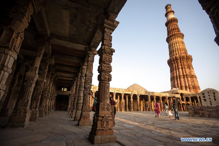 People visit the Qutab Minar in New Delhi, India, on April 5, 2013. Qutab Minar, a UNESCO World Heritage Site, is the tallest minaret in India. It is 75.56 metres high with a base a diameter of 14.3 metres, which narrows to 2.7 metres at the top storey. The minar is made of red sandstone and marble, and covered with intricate carvings. The construction of Qutab Minar started in 1193 by Qutub-ud-din Aibak and was completed by his inheritor Iltutmish. It is surrounded by several other ancient and medieval structures and ruins, collectively known as the Qutub complex, which attracts many visitors till now. (Xinhua/Zheng Huansong)