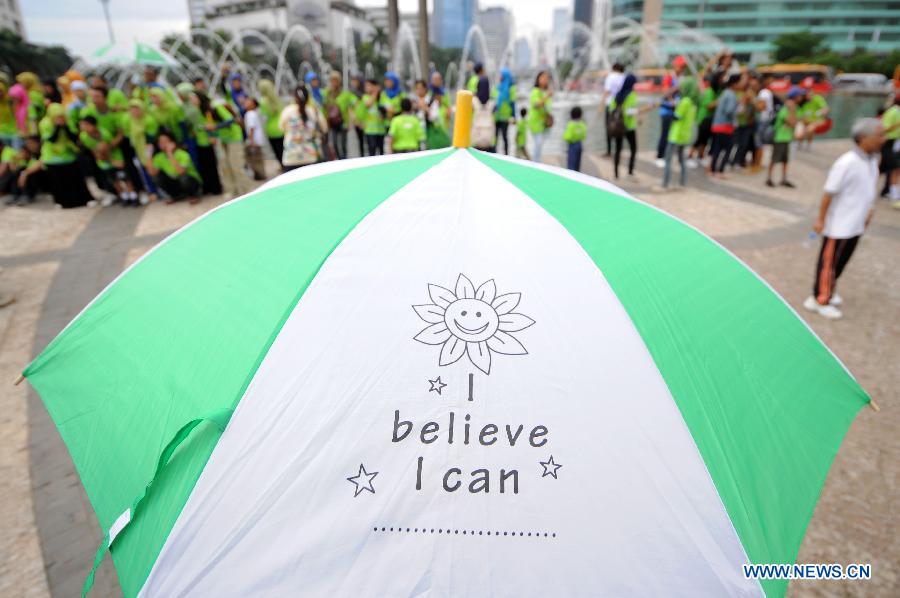 Participants take a break at Bundaran HI fountain during the annual Walk for Autism 2013 in Jakarta, Indonesia, April 6, 2013. Walk for Autism is one part of its autism awareness campaign. (Xinhua/Veri Sanovri)