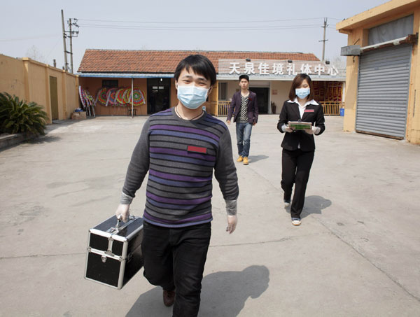 Three employees head for a mourning hall with their tools to cut hair and shave the departed. [Photo by Gao Erqiang / China Daily] 