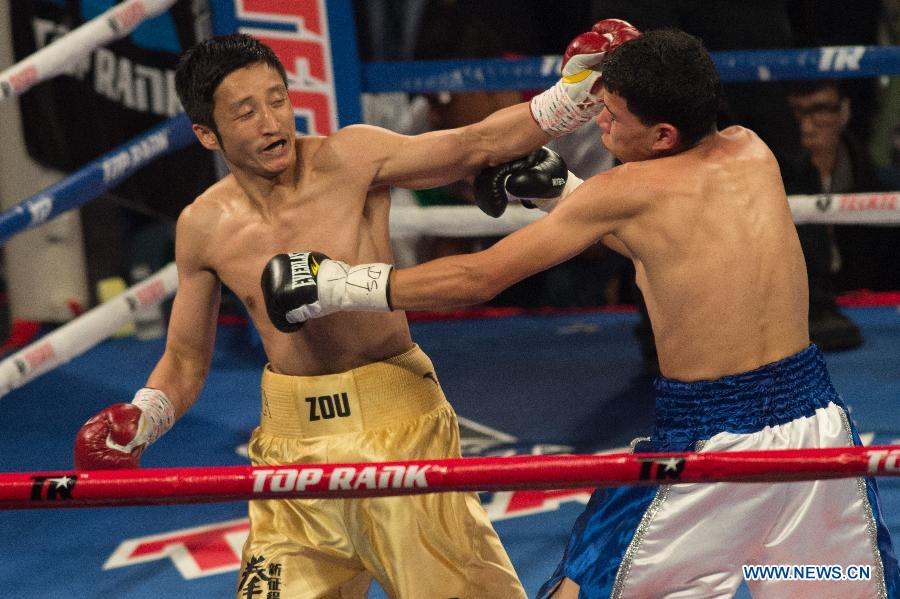 Two-time Olympic gold medalist China's Zou Shiming (L) lands a left during his professional debut against Mexico's Eleazar Valenzuela in Macau, China, April 6, 2013. (Xinhua/Cheong Kam Ka)