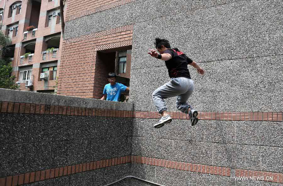 A young man practices parkour at the campus of Taiwan University in Taipei, southeast China's Taiwan, April 7, 2013. Parkour is an activity with the aim of moving from one point to another as efficiently and quickly as possible, using principally the abilities of the human body. (Xinhua/Xie Xiudong)