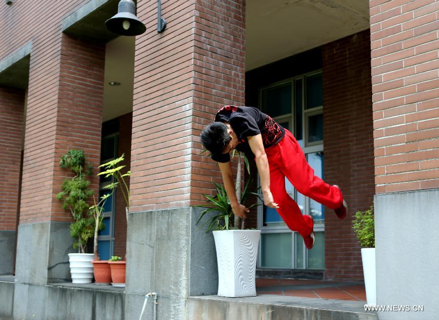 A young man practices parkour at the campus of Taiwan University in Taipei, southeast China's Taiwan, April 7, 2013. Parkour is an activity with the aim of moving from one point to another as efficiently and quickly as possible, using principally the abilities of the human body. (Xinhua/Xie Xiudong)