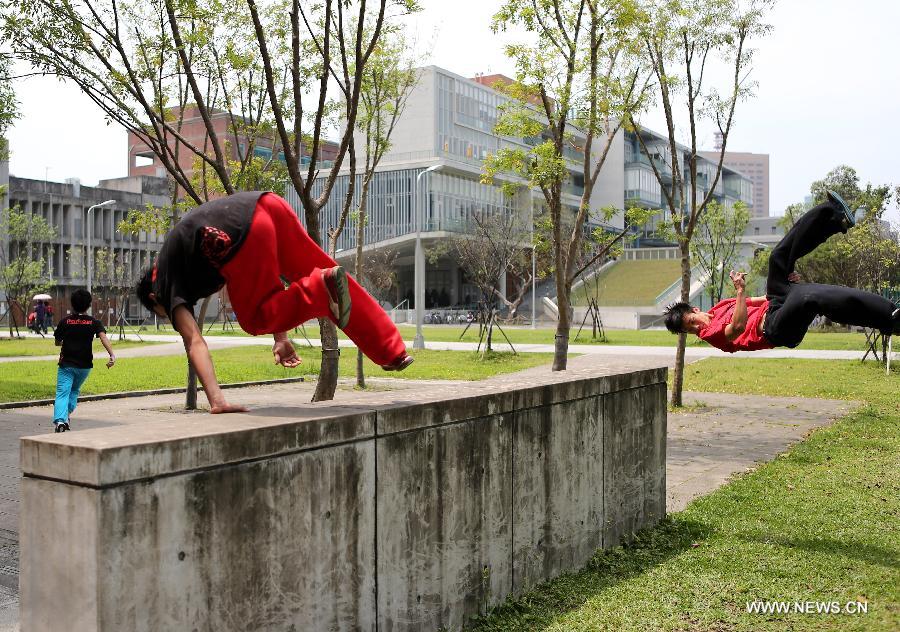 Young men practice parkour at the campus of Taiwan University in Taipei, southeast China's Taiwan, April 7, 2013. Parkour is an activity with the aim of moving from one point to another as efficiently and quickly as possible, using principally the abilities of the human body. (Xinhua/Xie Xiudong)