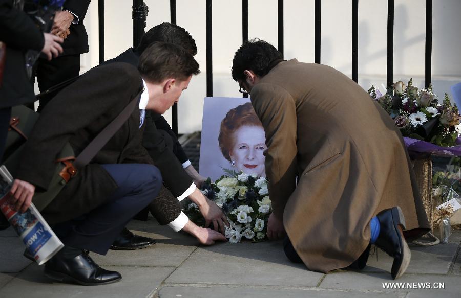 People lay flowers outside the residence of Baroness Thatcher at the Chester Square in London, Britain, on April 8, 2013. It has been confirmed that Lady Thatcher died this morning following a stroke at the age of 87. (Xinhua/Wang Lili)