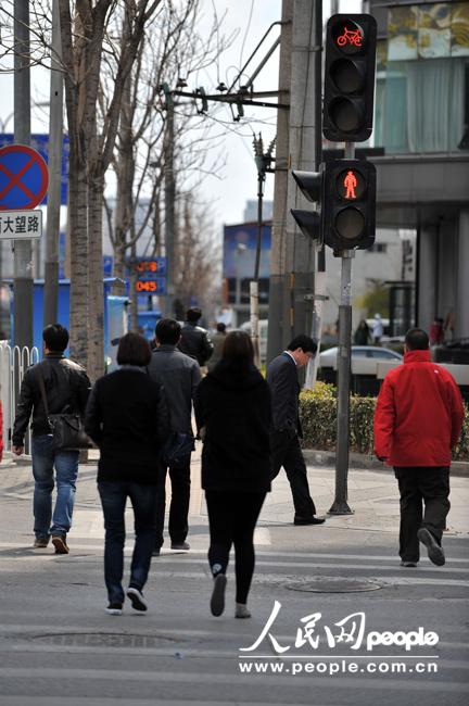 Pedestrians and cyclists jaywalk despite of red light at a crossing of Da Wang Road on April 9,2013. (People's Daily Online/Weng Qiyu)