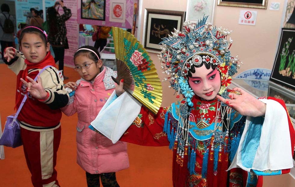 Lu Yanxi (R1), a third grade student, teaches her classmate to perform Peking Opera “Farewell to My Concubine” in Shanghai Zhabei District Primary School on March 30, 2013. It is part of the culture exhibition “Chinese dream on campus” project.