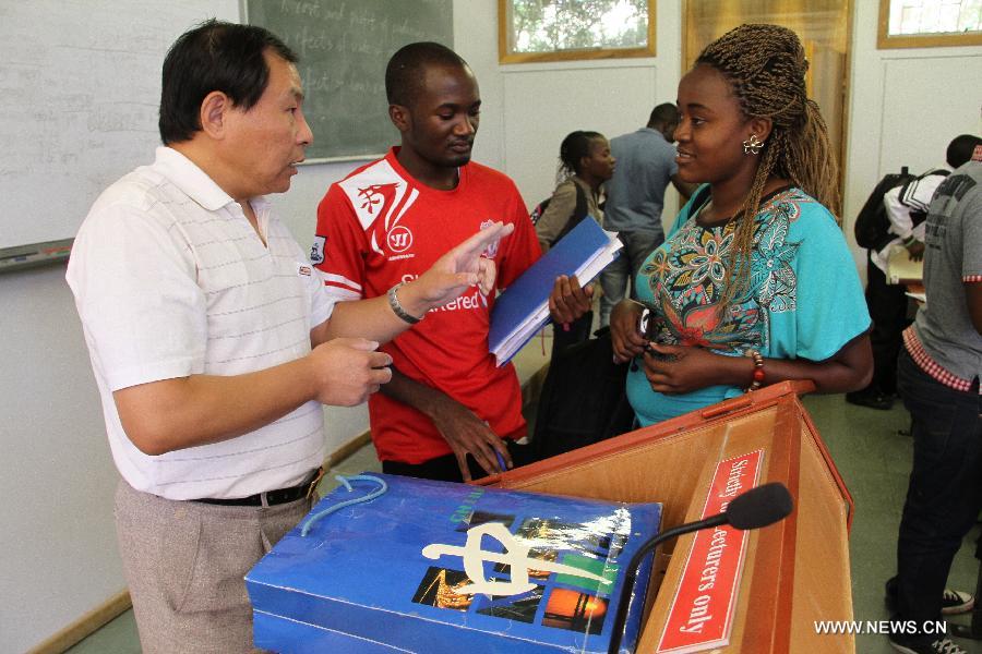 Wang Jiuliang, a chemistry teacher from China, communicates with Namibian students after chemistry class at University of Namibia in Windhoek, Namibia, April 9, 2013. To fulfill the agreement on higher-education cooperation between China and Namibia, China's universities started dispatching teachers to work at University of Namibia since mid-1990s. The Chinese teachers have since gained respect and good reputation because of their diligent work and serious attitude in academics. They have made remarkable contributions to the cultivation of local talents and the friendship between China and Namibia. (Xinhua/Gao Lei) 