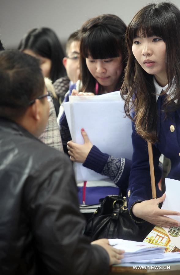 Job hunters inquire information at a job fair at the Tianjin University of Finance and Economics in Tianjin, north China, April 10, 2013. The job fair attracted 225 enterprises and institutions, providing 4,700 job vacancies for college graduates. (Xinhua/Liu Dongyue) 