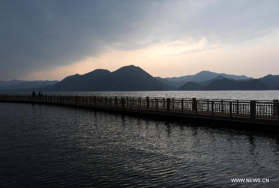 Visitors walk on a wooden bridge of the Taiping Lake in the scenic area of Huangshan Mountain, east China's Anhui Province, April 8, 2013. (Xinhua/Yan Yan)