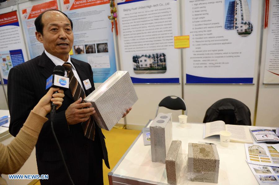 Zhu Hengjie from China introduces an invention of ASA external wall for light steel structure ASA plate inlaid type integrated energy-saving building features with low energy consumption and price on the 41st International Exhibition of Inventions of Geneva, in Palexpo of Geneva, Switzerland, April 10, 2013. Some 50 Chinese participants came to the exhibition to display their 23 objects of invention. (Xinhua/Wang Siwei) 