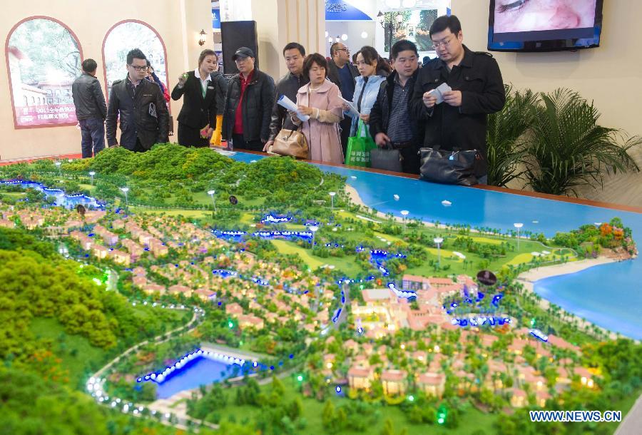 People visit a sand table of a property project at Beijing Spring Real Estate Trade Fair in Beijing, capital of China, April 11, 2013. The four-day fair kicked off on Thursday. (Xinhua/Luo Xiaoguang)