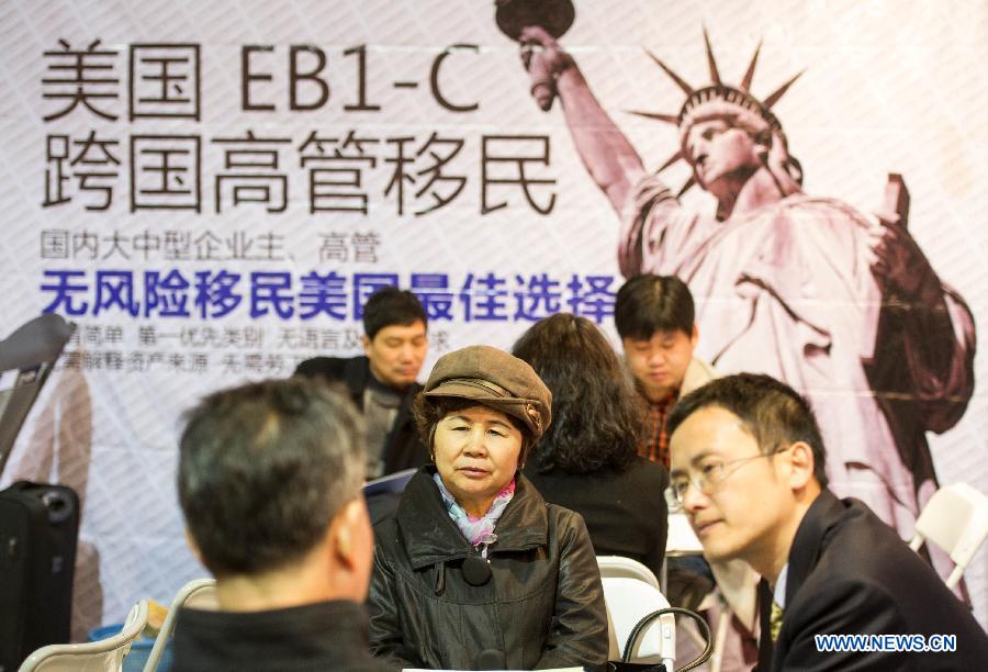 People learn the information of overseas investment and immigration during the Beijing Spring Real Estate Trade Fair in Beijing, capital of China, April 11, 2013. The four-day fair kicked off on Thursday. (Xinhua/Luo Xiaoguang)