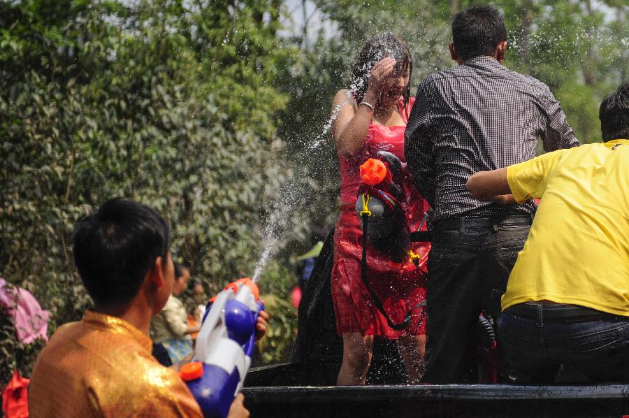 A young man sprinkles water during a celebration marking the upcoming Water Splashing Festival in Mangshi, southwest China's Yunnan Province, April 11, 2013. The Water Splashing Festival, also the New Year of the Dai ethnic group, will last for three or four days. (Xinhua/Qin Lang)