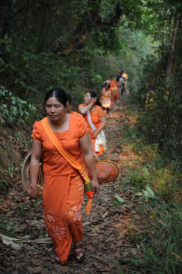 Women in folk costumes go into the mountains to pick flowers during a celebration marking the upcoming Water Splashing Festival in Mangshi, southwest China's Yunnan Province, April 11, 2013. The Water Splashing Festival, also the New Year of the Dai ethnic group, will last for three or four days. (Xinhua/Qin Lang)