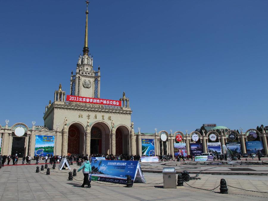 People walk to the venue of the 2013 Spring Beijing International Property Expo in Beijing, capital of China, April 11, 2013. The four-day expo kicked off on Thursday at Beijing Exhibition Centre. (Xinhua/Wang Yueling)