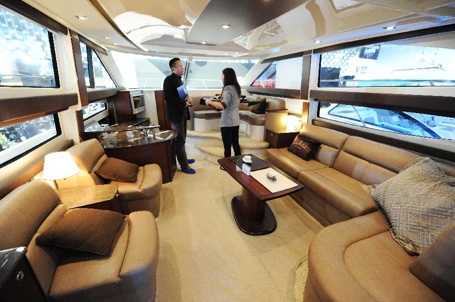 An exhibitor introduces a luxury yacht to a visitor during the 18th China (Shanghai) International Boat Show (CIBS) at the Shanghai World Expo Exhibition & Convention Center in Shanghai, east China, April 11, 2013. A total of 550 real boats from 500 exhibitors were displayed at the 4-day-long CIBS that kicked off on Thursday. (Xinhua/Lai Xinlin)