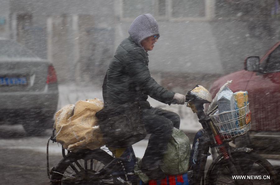 A deliveryman rides in snow in Changchun, capital of northeast China's Jilin Province, April 11, 2013. (Xinhua/Lin Hong)