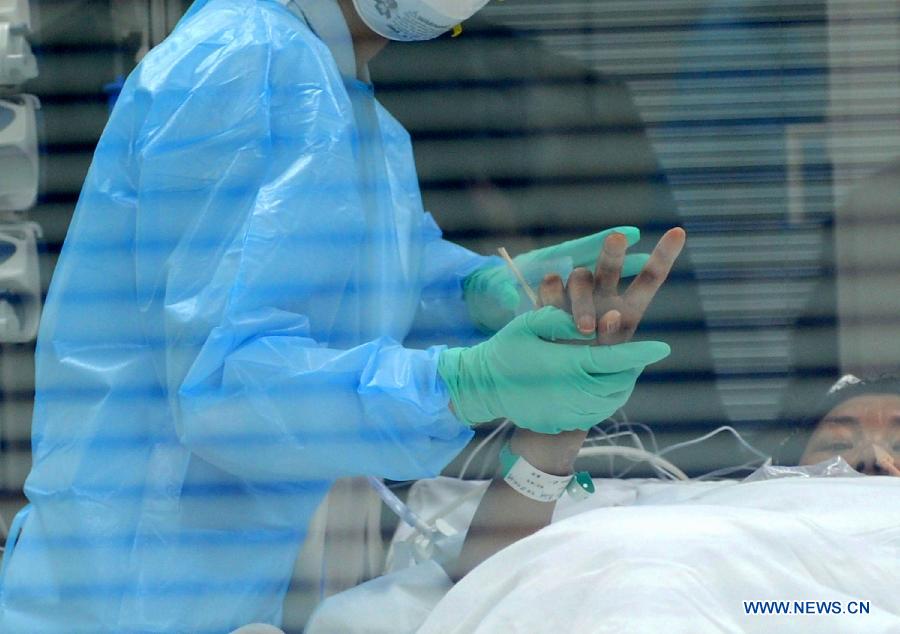 A nurse takes care of a H7N9-contracted patient at the Nanjing Drum Tower Hospital in Nanjing, capital of east China's Jiangsu Province, April 12, 2103. A seven-year-old girl in Beijing was infected with the H7N9 strain of bird flu, the first such case in the Chinese capital, local health authorities said Saturday. The new case raised the number of H7N9 infections in China to 44, with all the other 43 in the eastern parts of the country. The first known human infections have claimed the lives of 11 people, according to the National Health and Family Planning Commission. (Xinhua/Sun Can)