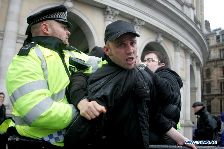 A protester clashes with police during a party marking former British Prime Minister Margaret Thatcher's death in central London's Trafalgar square, on April 13, 2013. Parties staged by opponents of Margaret Thatcher to celebrate her death took place in several locations across the UK on Saturday. (Xinhua/Bimal Gautam) 