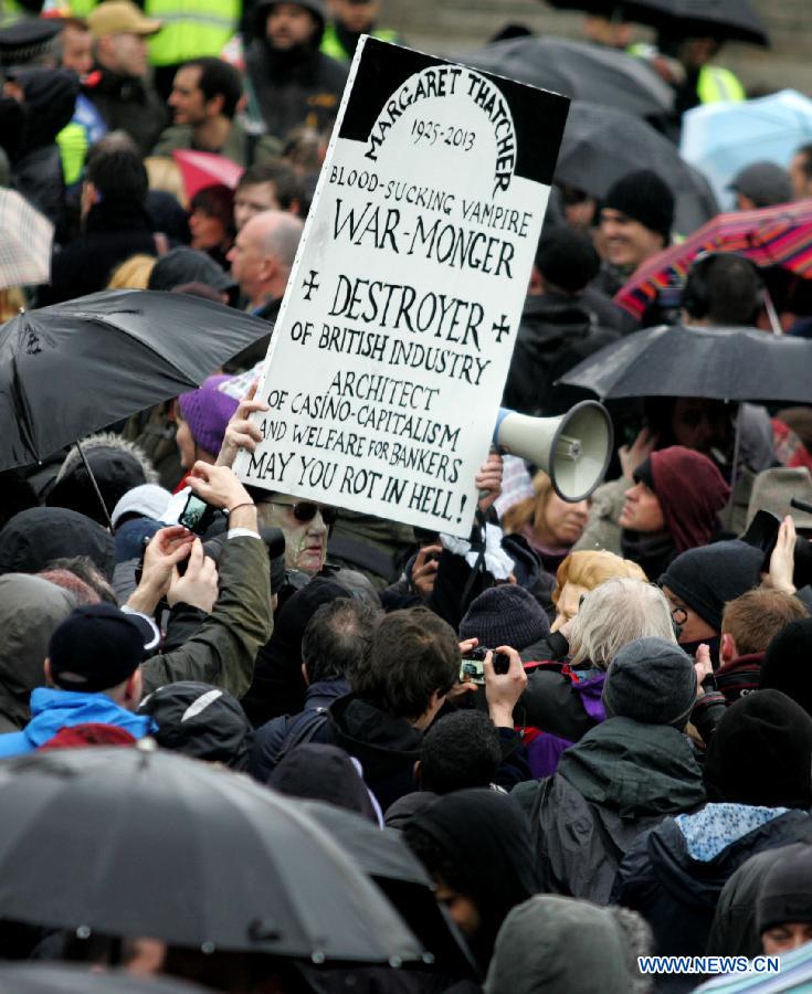 A protester holds a placard during a party marking former British Prime Minister Margaret Thatcher's death in central London's Trafalgar square, on April 13, 2013. Parties staged by opponents of Margaret Thatcher to celebrate her death took place in several locations across the UK on Saturday. (Xinhua/Bimal Gautam) 