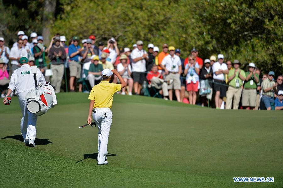 China's Guan Tianlang (R) greets the audience on the first hole during the third round of the 2013 Masters golf tournament at the Augusta National Golf Club in Augusta, Georgia, the United States, April 13, 2013. Guan shot a five-over par 77 Saturday. (Xinhua/Charles Laberge/Augusta National)