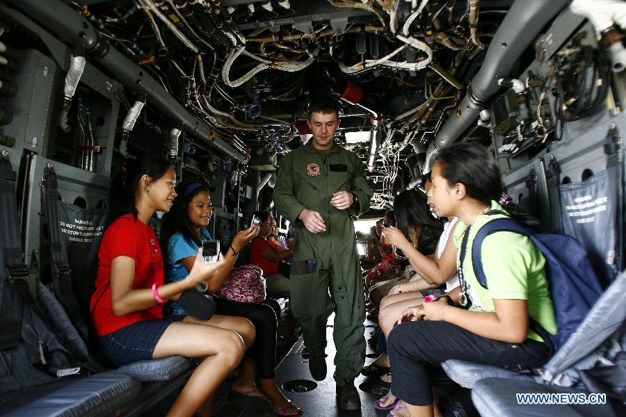 Children sit inside the MV-22 Osprey as a U.S. Air Force pilot passes during an aircraft static display as part of a joint military exercise in Pampanga Province, the Philippines, April 13, 2013. The Philippines and the U.S. held their 29th annual joint military exercise with at least 8,000 American and Filipino soldiers participating in the training. The joint military exercise, more known as Balikatan, which means "shoulder-to-shoulder" in Filipino, is held from April 5 to 17. (Xinhua/Rouelle Umali)
