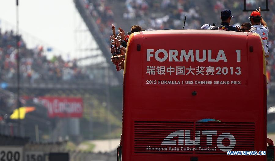 F1 drivers take part in the drivers parade prior to the start of the Chinese F1 Grand Prix at the Shanghai International circuit, in Shanghai, east China, on April 14, 2013. (Xinhua/Li Ming)