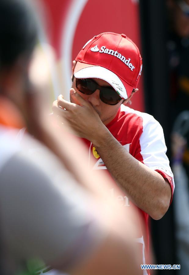 Ferrari driver Felipe Massa of Brazil reacts after the drivers parade prior to the start of the Chinese F1 Grand Prix at the Shanghai International circuit, in Shanghai, east China, on April 14, 2013. (Xinhua/Li Ming)