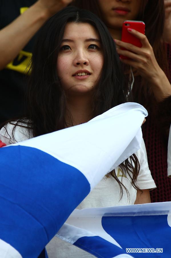 A fan of Lotus driver Kimi Raikkonen reacts during the drivers parade prior to the start of the Chinese F1 Grand Prix at the Shanghai International circuit, in Shanghai, east China, on April 14, 2013. (Xinhua/Li Ming)