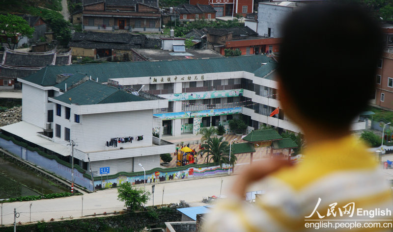 The younger son of Bing always watches the kindergarten with envy. He was infected with HIV by mother-to-child transmission since he was born. He wasn't accepted by the only kindergarten in the county. (CFP/Pan Deng)