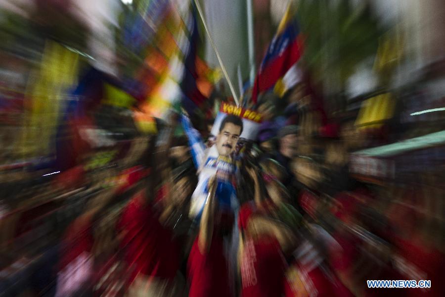 Supporters of Venezuelan acting President Nicolas Maduro celebrate his victory in Caracas, capital of Venezuela, on April 14, 2013. Venezuelan Acting President Nicolas Maduro narrowly won the presidential election with 50.66 percent of the votes, National Electoral Council's President Tibisay Lucena said on Sunday. (Xinhua/David de la Paz)