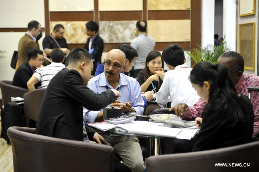 Exhibitors and businessmen talk during the 113th China Import and Export Fair in Guangzhou, capital of south China's Guangdong Province, April 15, 2013. The three-week 113th China Import and Export Fair kicked off here on Monday. (Xinhua/Liang Xu)