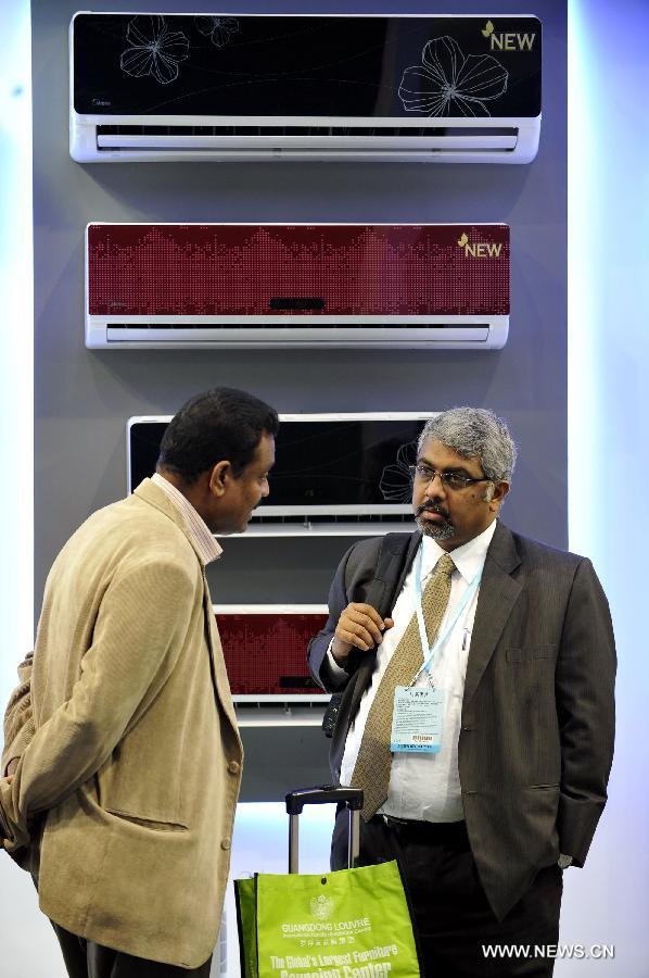 Two businessmen stand in front of air-conditoners at the 113th China Import and Export Fair in Guangzhou, capital of south China's Guangdong Province, April 15, 2013. The three-week 113th China Import and Export Fair kicked off here on Monday. (Xinhua/Lu Hanxin)