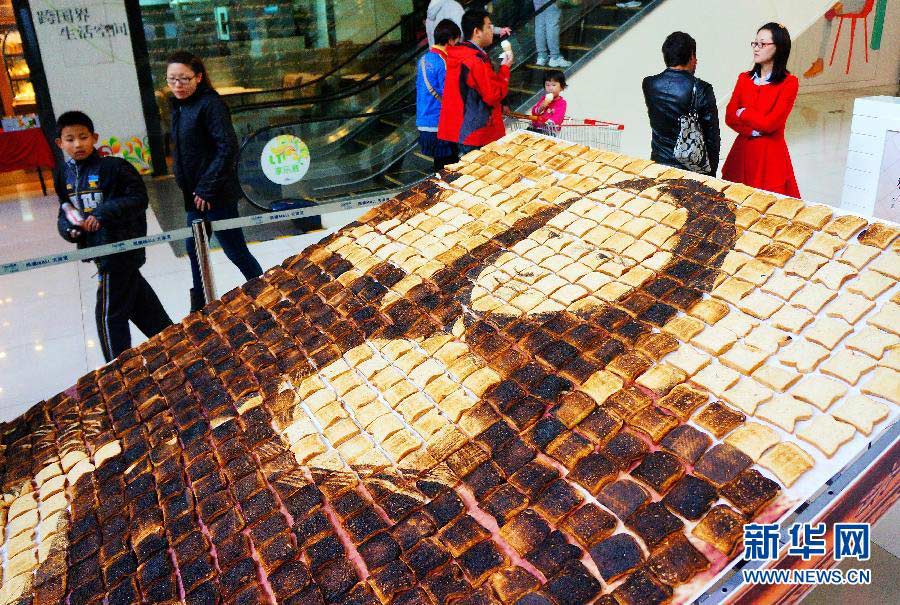 People look at a "Mona Lisa" portrait made from expired bread in a shopping mall in Tianjin, April 14, 2013. (Xinhua/You Sixing)